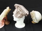 Plusieurs chapeaux sont alignés sur une surface noire