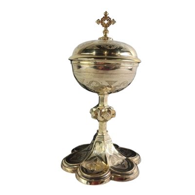 un calice en argent richement décoré, surmonté d'une croix