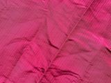 pink bed sheet with a pink pillow on top of it