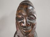 an image of a wooden statue of a man with a smile on his face