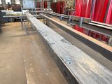 a long row of benches in a building with red chairs
