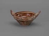 a brown and white bowl sitting on top of a gray surface