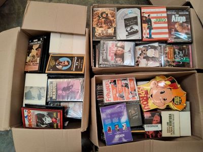 un grand nombre de dvd dans une boîte posée sur le sol
