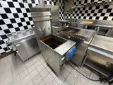 une cuisine avec un mur à carreaux et des appareils électroménagers en inox