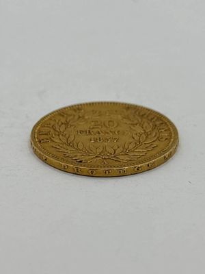 gros plan d'une pièce d'or sur une surface blanche