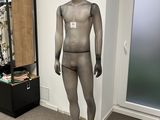 un mannequin au milieu d'une pièce, avec un bureau en arrière-plan