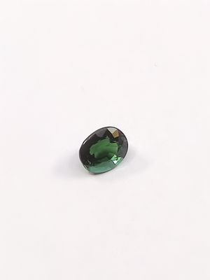 une tourmaline verte posée sur un fond blanc