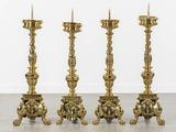 three gold candles are sitting on top of each other in a room