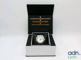 l'image d'une montre dans une boîte sur une surface blanche