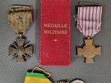 plusieurs médailles posées sur une table, à côté d'un livre rouge
