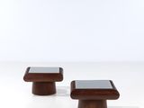 a pair of wooden stools with a glass top on a white surface