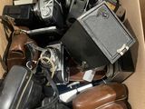 a cardboard box full of old cameras and other items