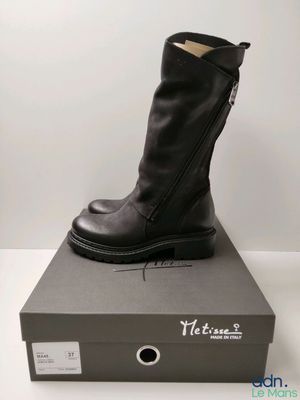 Les bottes noires sont posées sur la boîte, sur la table.