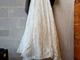 a wedding dress hanging on a clothes rack in a room