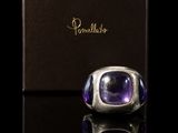 une bague sertie d'une pierre d'améthorate, présentée dans un écrin