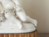 a figurine of a boy and a girl on a marble base