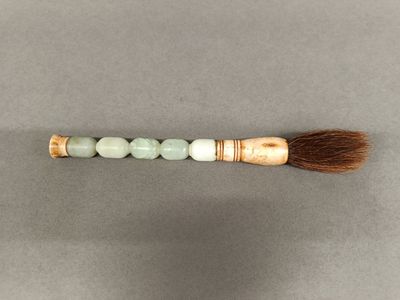 a close up of a brush with a long handle on a table