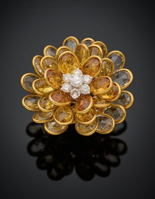 une broche en forme de fleur en diamants jaunes et blancs sur un fond noir