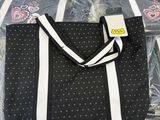 a black and white polka dot tote bag with a white stripe