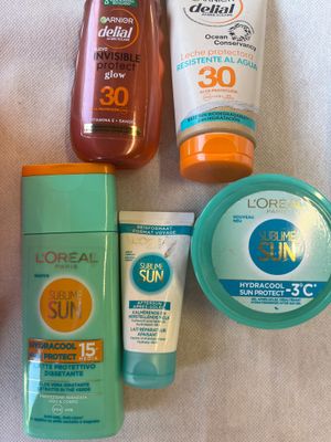 plusieurs crèmes solaires et lotions posées sur une serviette
