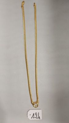 gros plan sur un collier en or portant une étiquette