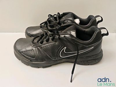 chaussures Nike noires avec des lacets noirs sur un fond blanc