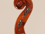 a close up of the back of a violin with a fiddle in the foreground