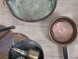 several pots and pans are sitting on a wooden table
