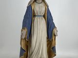 La statue de la Vierge Marie se dresse sur un piédestal.