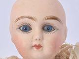 a close up of a doll with blue eyes on a white background
