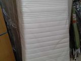 un matelas posé dans un coin de la pièce