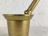 a brass mortar with a pestula in it on a table