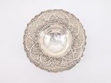 a silver plate with a pearl in the center on a white surface