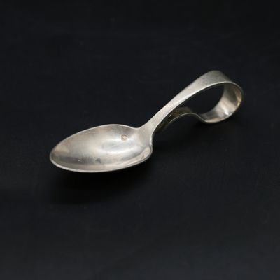 silver spoon on a black surface with a black background