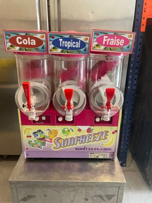 three soda machines on display for sale in a store