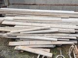 un tas de bois posé sur le sol à côté d'un bâtiment