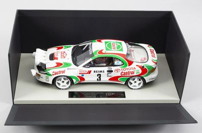 une maquette de voiture dans une vitrine posée sur une surface blanche