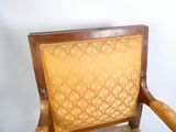 une chaise en bois dont l'assise est recouverte d'un tissu jaune