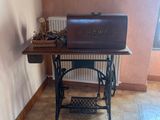une petite table sur laquelle est posé un ordinateur portable, dans un coin de la pièce