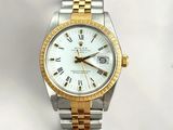 a gold and silver watch with roman numerals on it