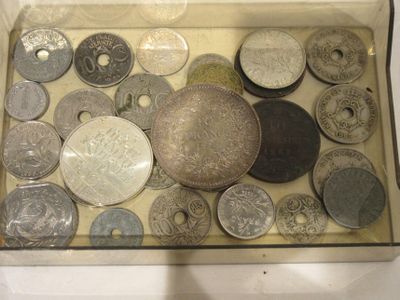 many different coins in a glass box on the table