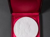 a white medallion in a red box on a black surface