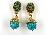 a pair of turquoise and gold earrings on a white background