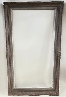 Un cadre en bois sculpté et cérusé gris.