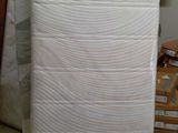 un matelas posé au milieu d'une pile de cartons