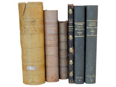 several old books are lined up in a row on a white surface