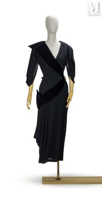 mannequin vêtu d'une robe noire, posé sur un socle en bois, sur fond blanc
