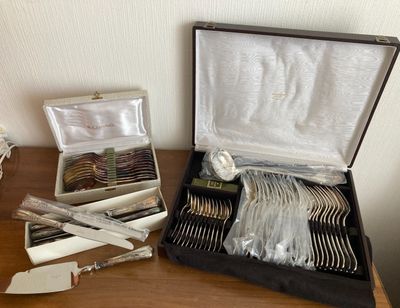 a box of silverware on a table with a knife, fork and spoons