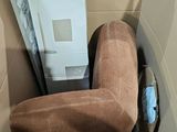 a brown couch in a box with a white refrigerator in it