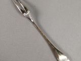 a silver spoon and fork on a white surface